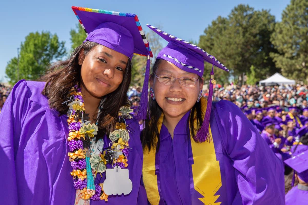 Two excited SJC graduates posing for a picture at Graduation